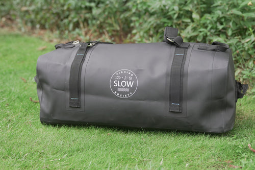 Black Slow Fishing Society waterproof duffle on grass