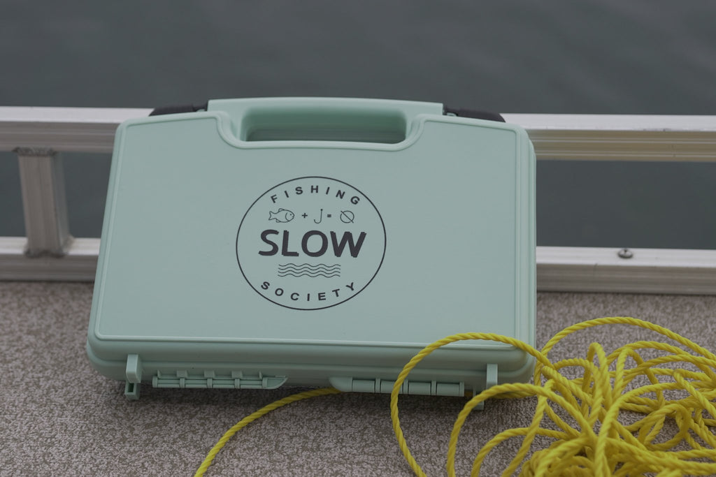 SLOW fly box on a boat deck beside yellow rope