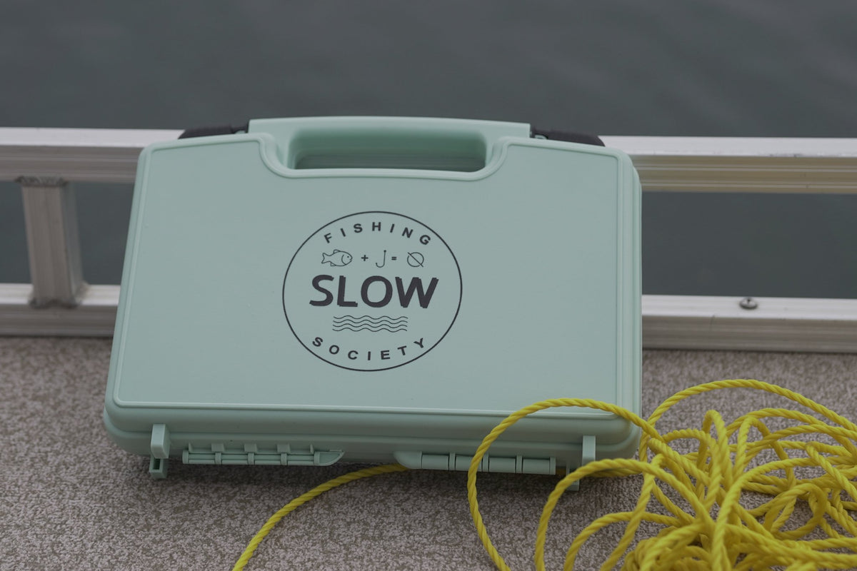 SLOW fly box on a boat deck beside yellow rope